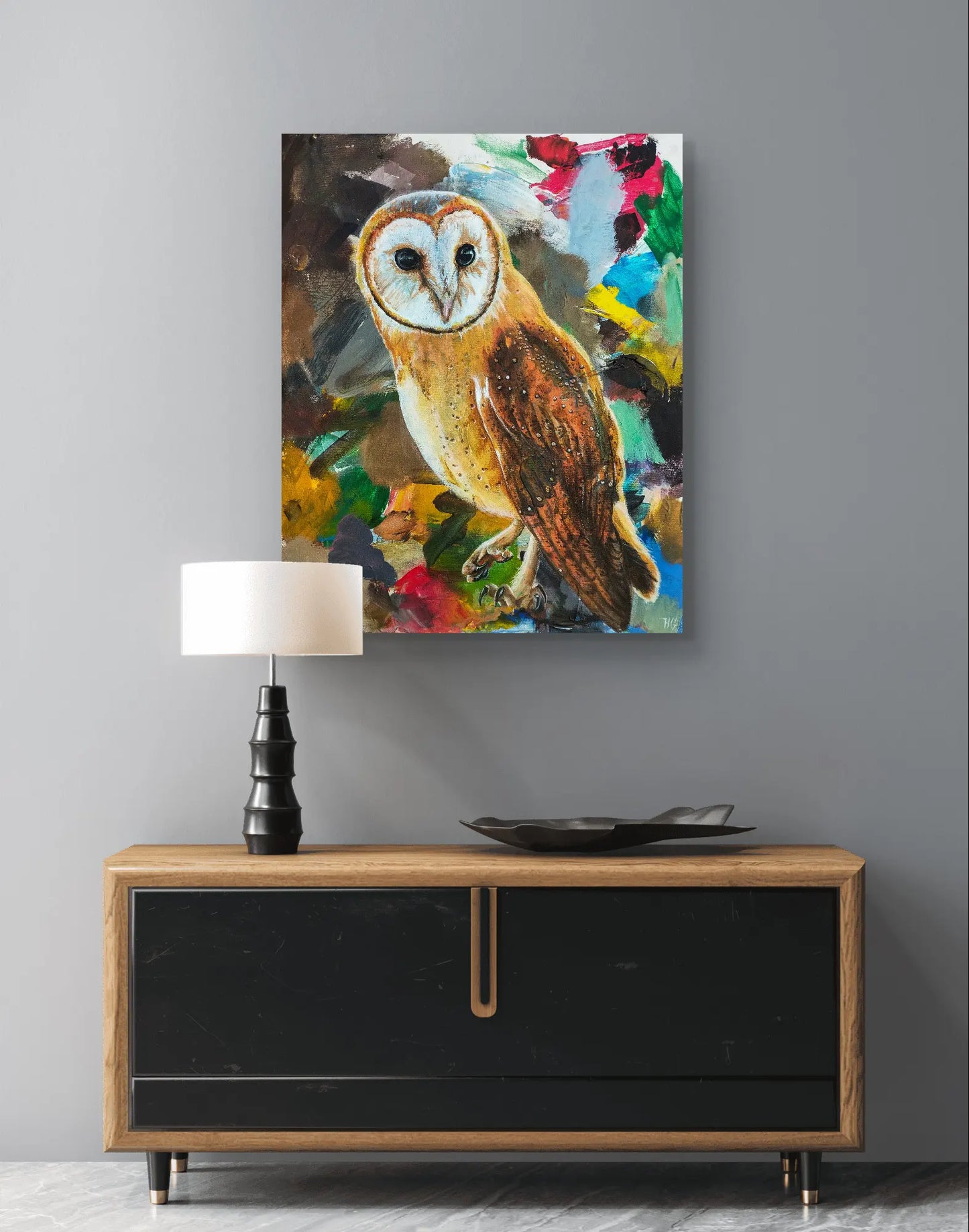 Schleiereulen-Gemälde an dunkelgrauer Wand über modernem Sideboard mit Tischlampe