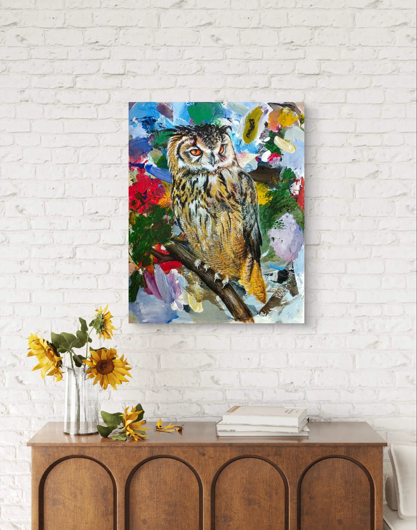 Expressives Waldohreule Acryl-Gemälde hängt an einer weißen Backsteinwand über einer Holzkommode mit Sonnenblumen