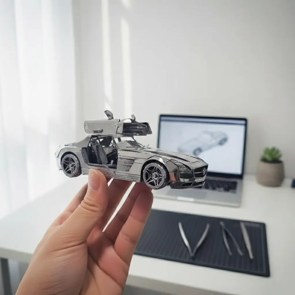 3D-Metallpuzzle, Mercedes-Benz SLS AMG, mit Flügeltüren in der Hand über dem Bautisch, der eine Pinzette zeigt.