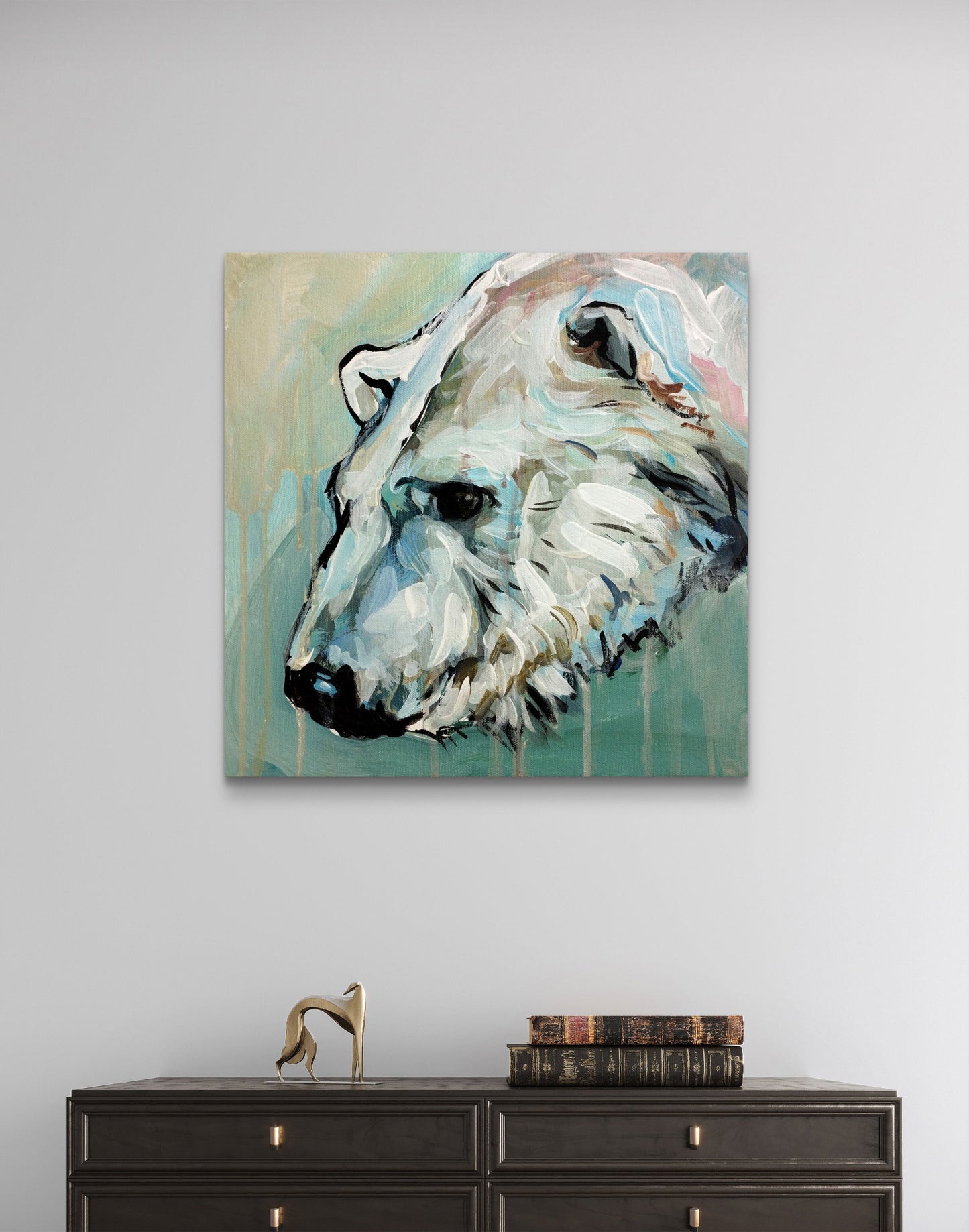 Acrylgemälde Eisbär hängt über einer dunklen Kommode im Wohnzimmer, ergänzt durch eine goldene Dekofigur.