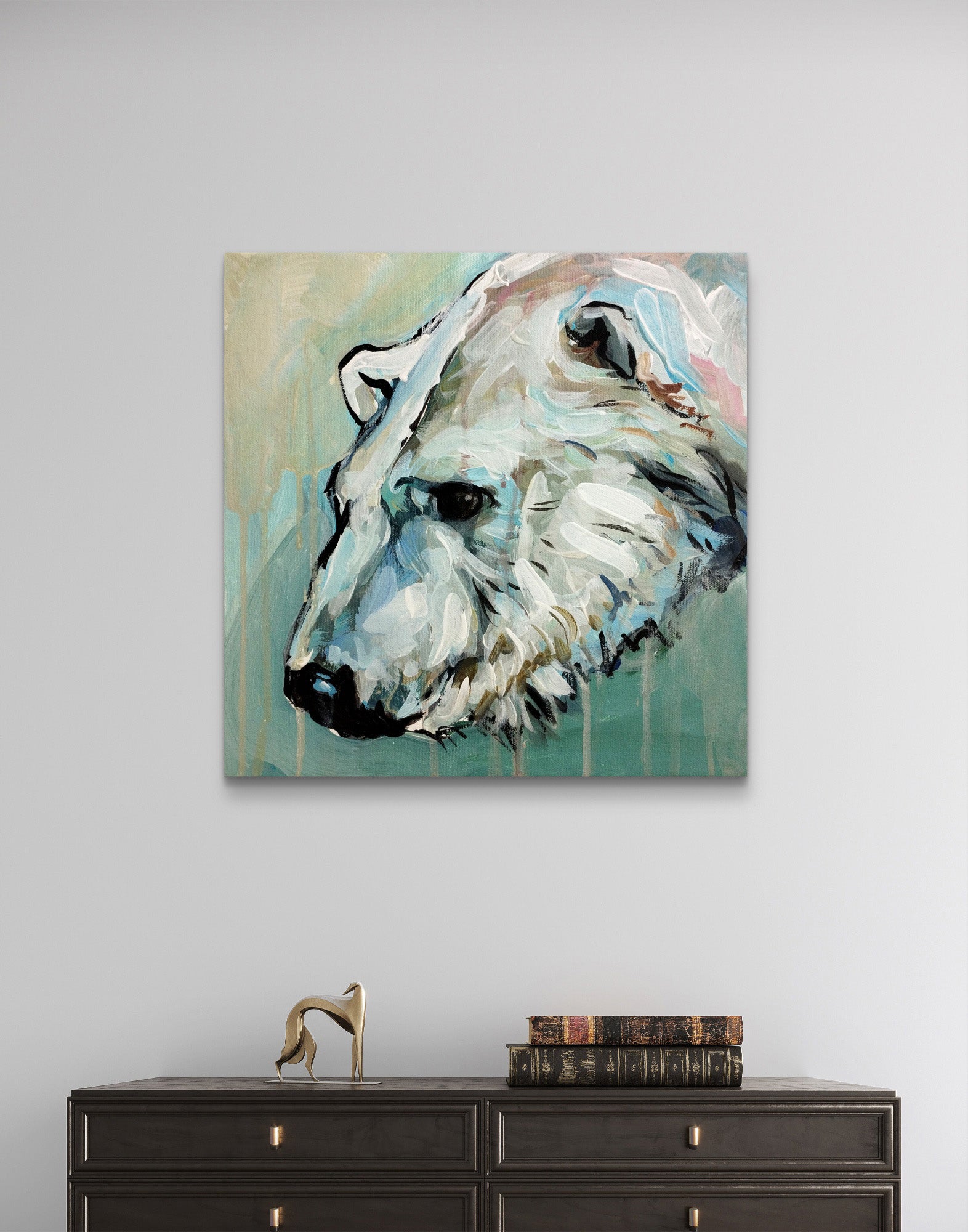 Acrylgemälde Eisbär hängt über einer dunklen Kommode im Wohnzimmer, ergänzt durch eine goldene Dekofigur.