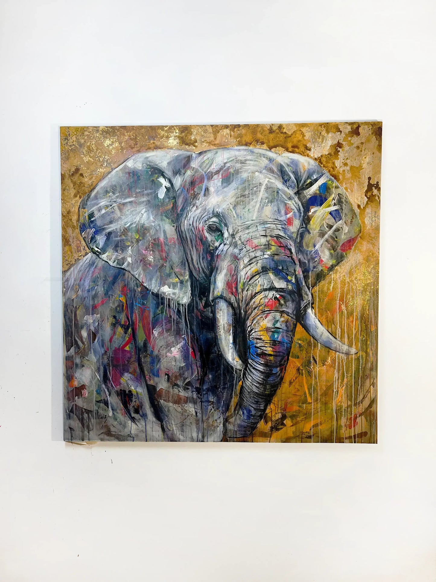 Acrylgemälde Elefant im expressiven Stil, farbige Akzente auf grauem Rüssel und Ohren vor gold-gelbem Hintergrund.