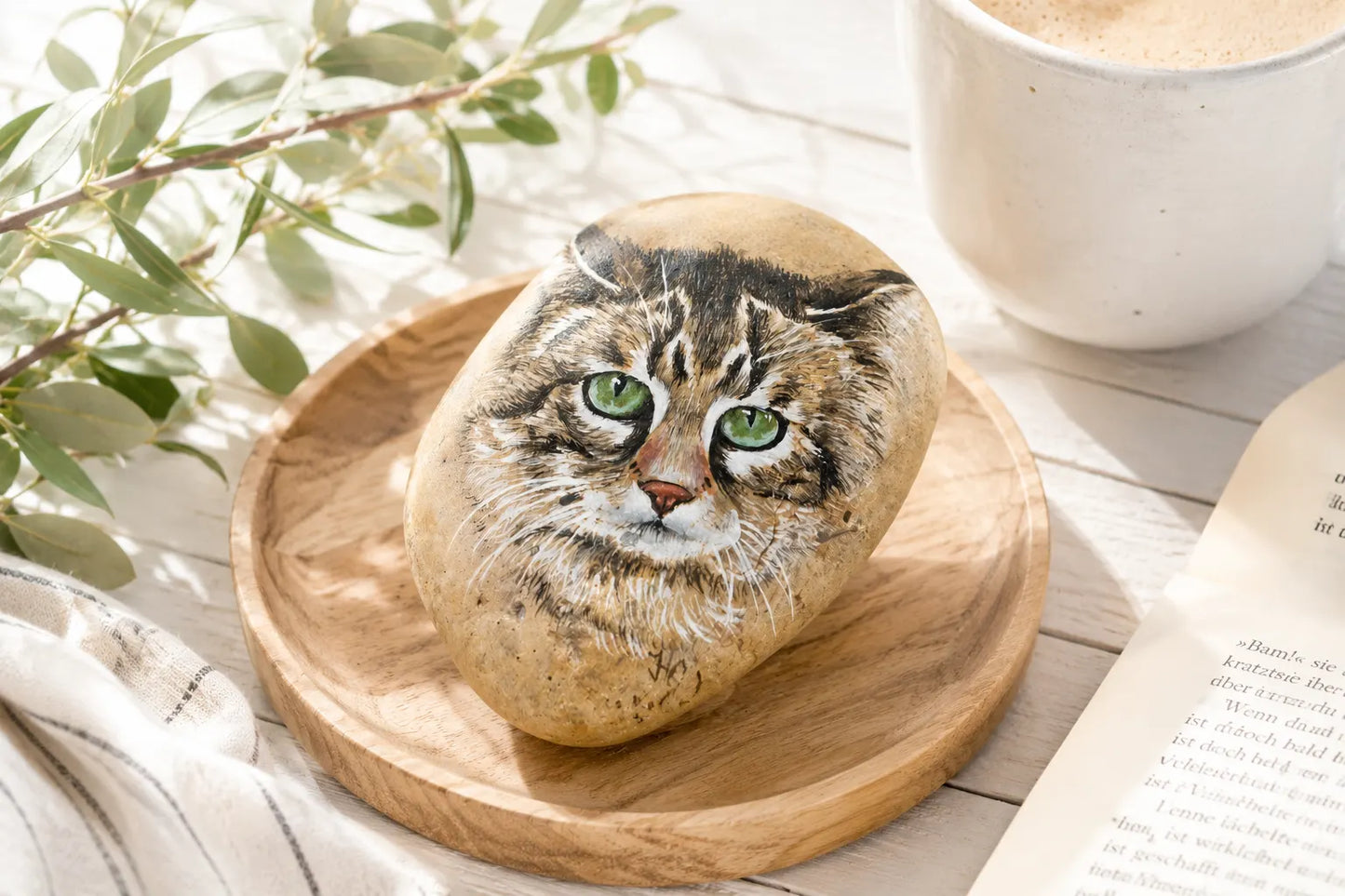 Bemalter Stein Katze auf Holzteller – Tischdeko Naturstein handbemalt, grüne Augen, Acrylmalerei