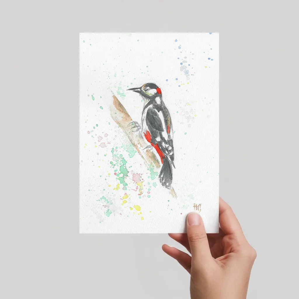 Aquarell Postkarte Buntspecht auf Rindenast, handgemalt, expressive Malweise mit bunten Farbspritzern.