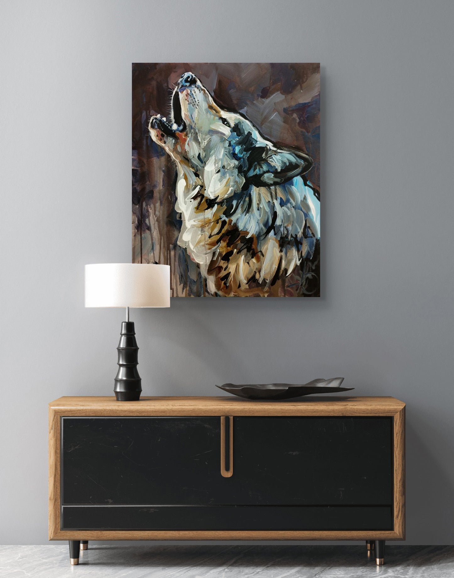 Expressives Wolf-Gemälde über modernem Sideboard mit schwarzer Front und Holzplatte vor grauer Wand.