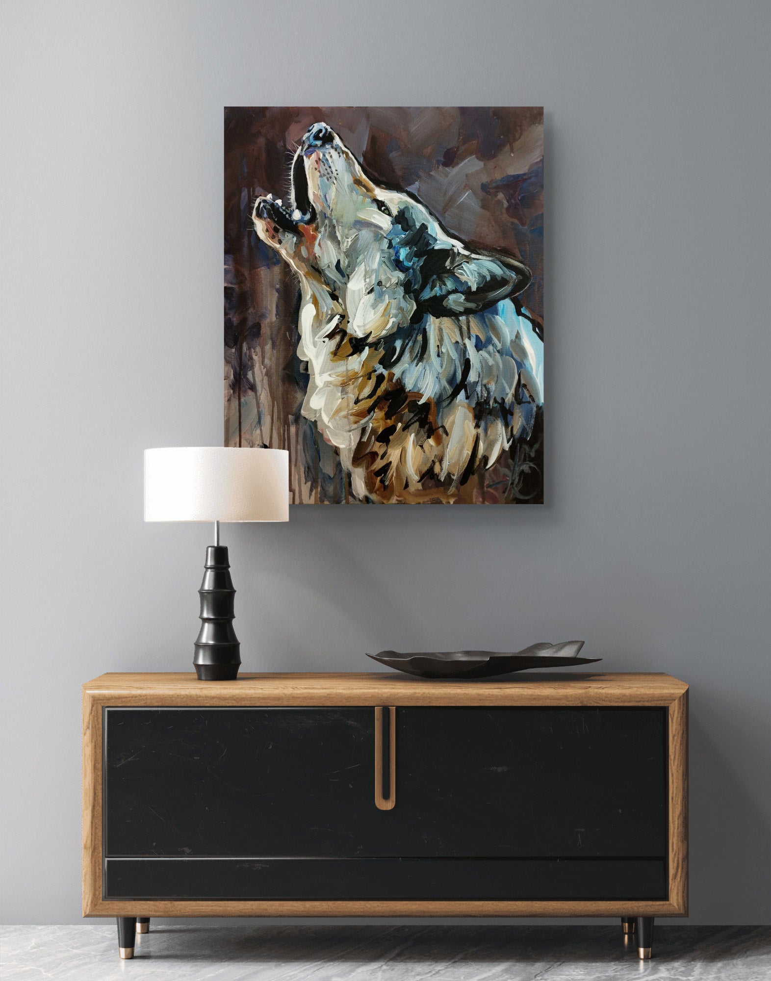 Expressives Wolf-Gemälde über modernem Sideboard mit schwarzer Front und Holzplatte vor grauer Wand.